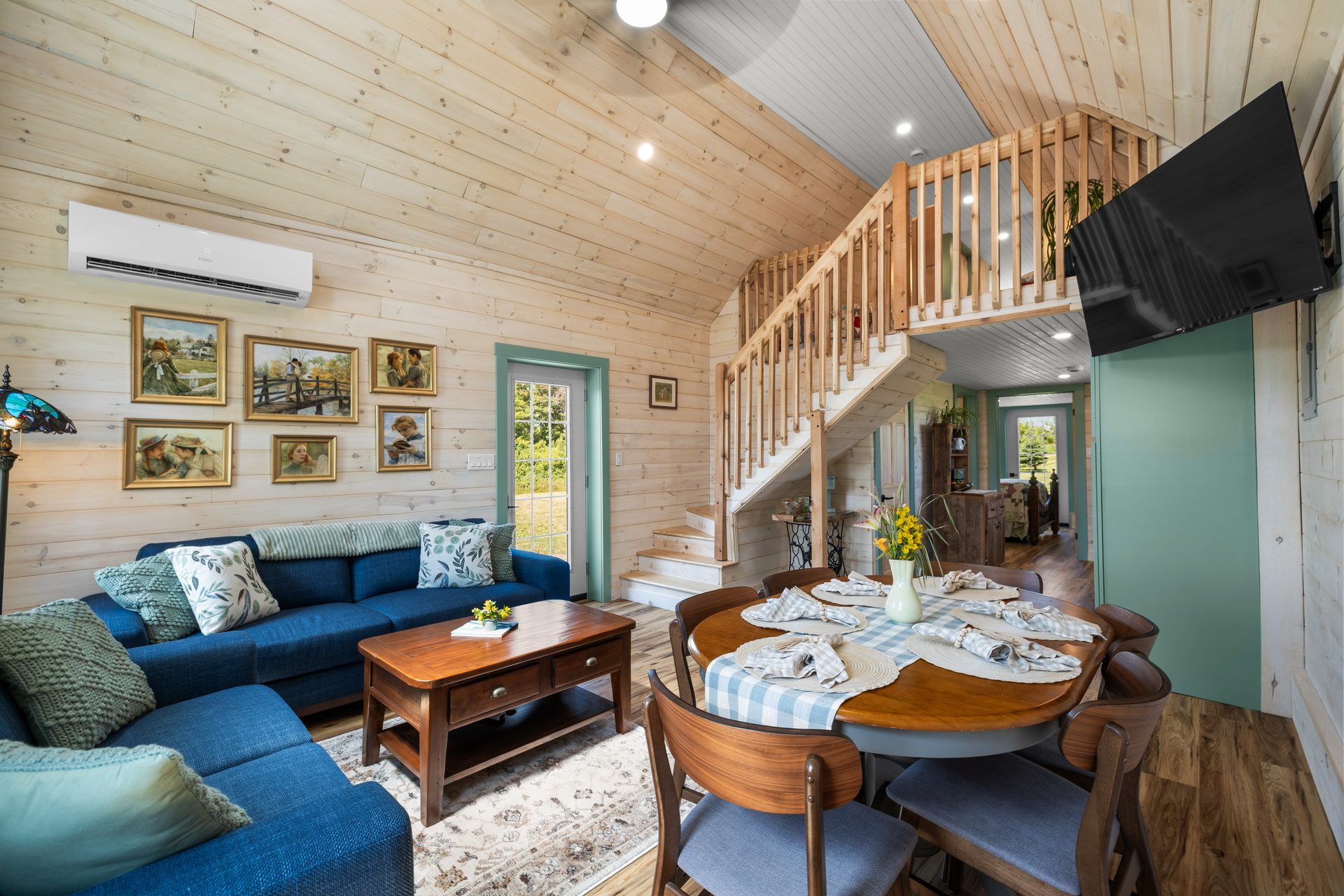 Cozy living room with loft above at Four Winds Cottage